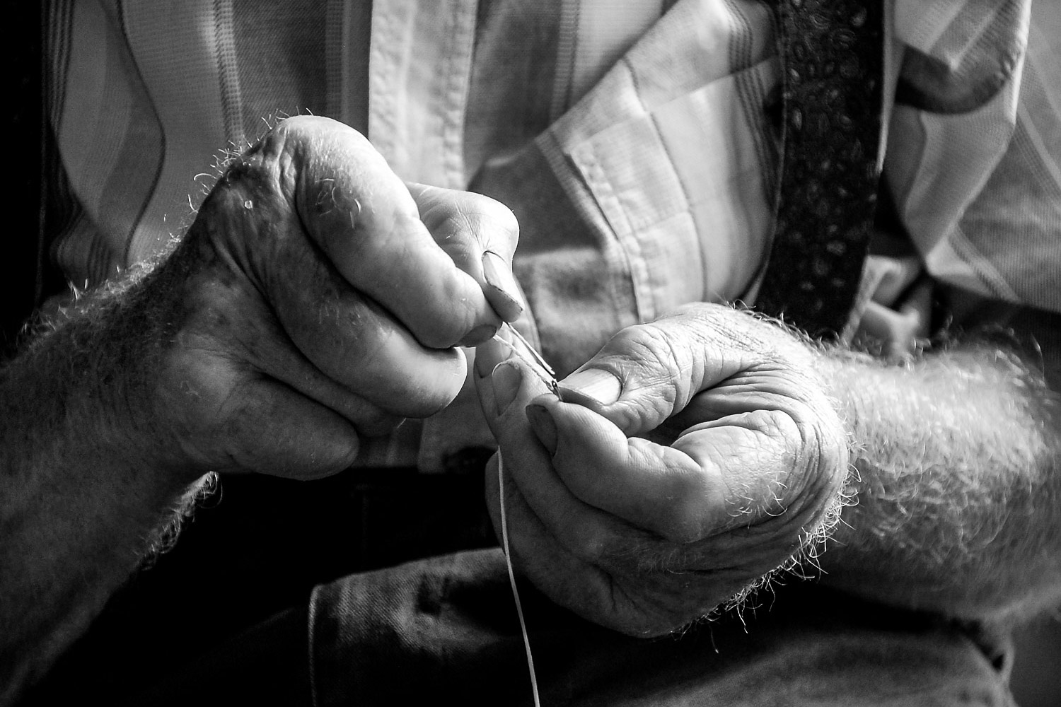 Fotografie-Handwerk-schwarzweiss_ricarts Fotografie-Handwerk-Mann-mit-Nadel-u-Faden
