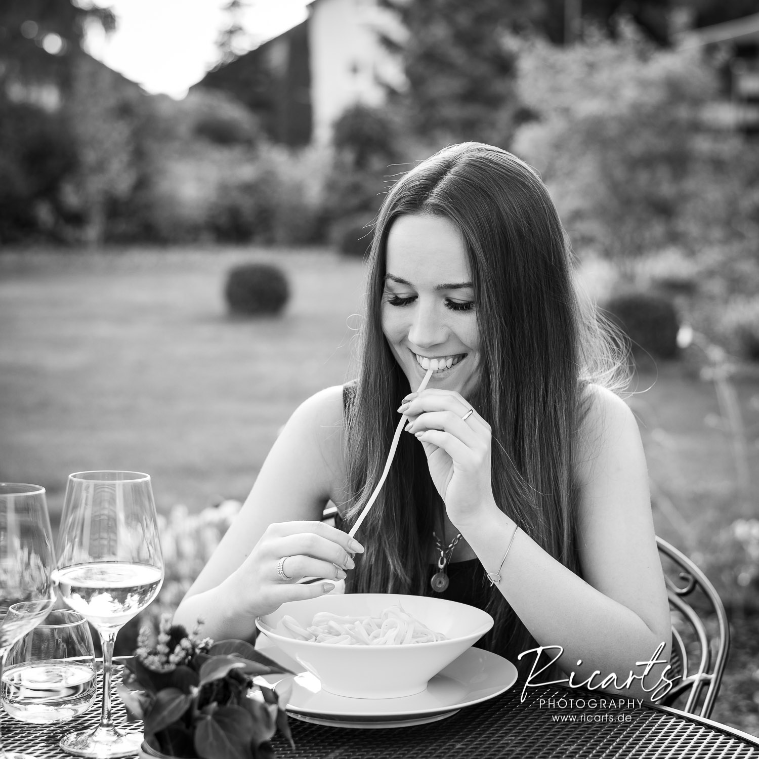 Junge Frau am Tisch isst Spaghetti