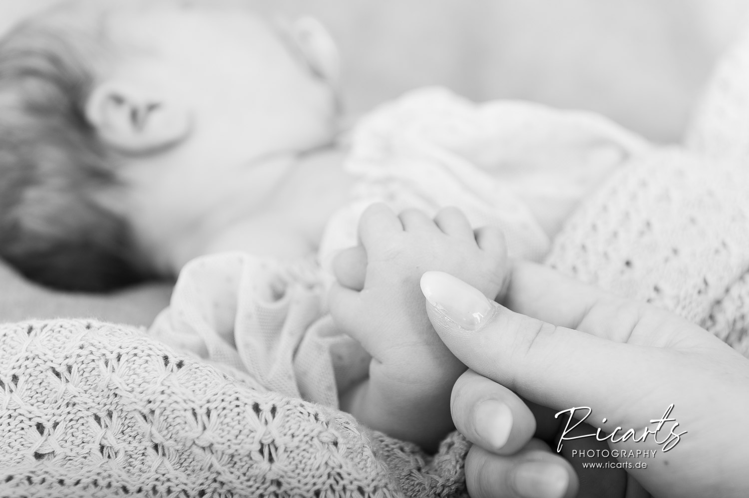 Mutter-hält-Händchen-von-Newborn-Baby