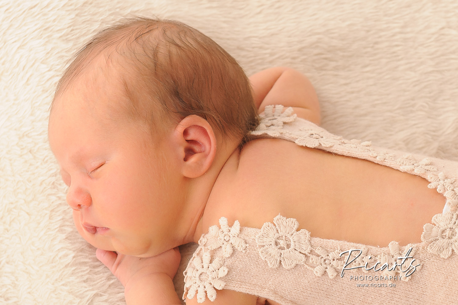 Newborn-Baby-liegt-schlafend-auf-dem-Bauch
