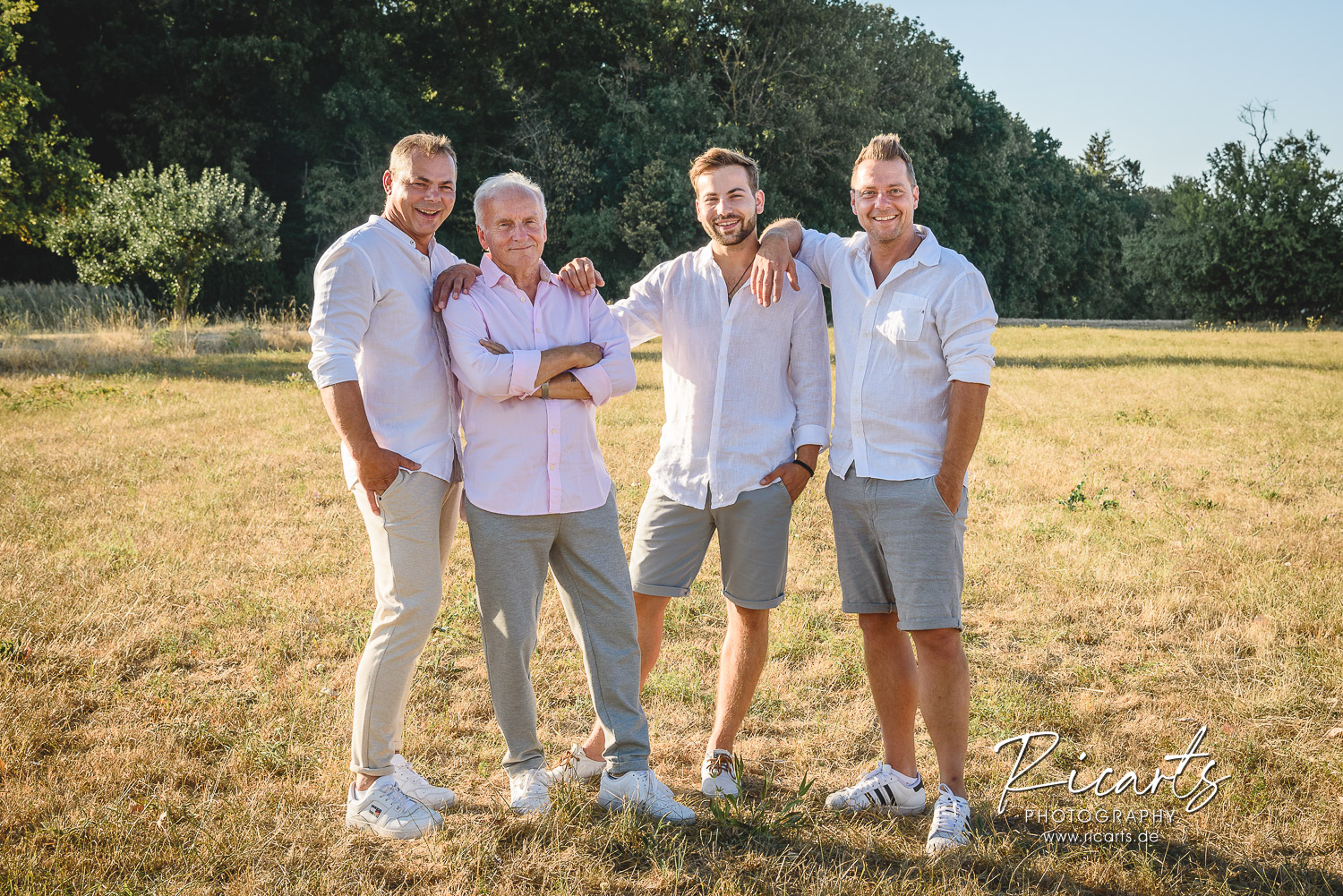 Familienfoto-Vater-mit-Söhnen-und-Enkel-auf-Sommerwiese