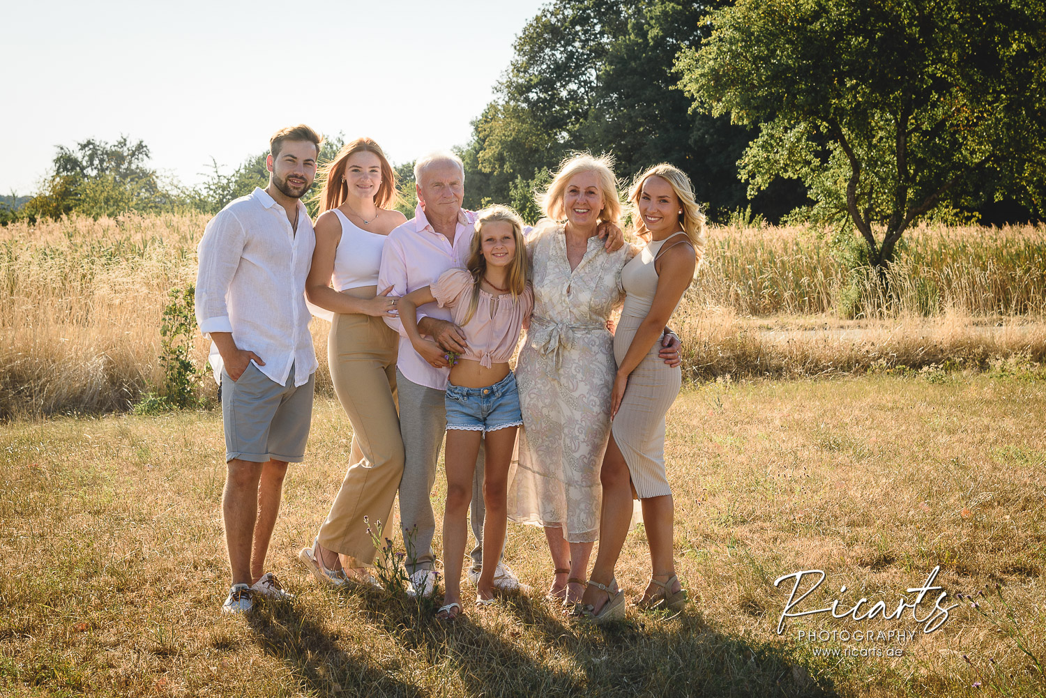 Familienfoto-Grosseltern-Enkel-auf-einer-Wiese-im-Sommer