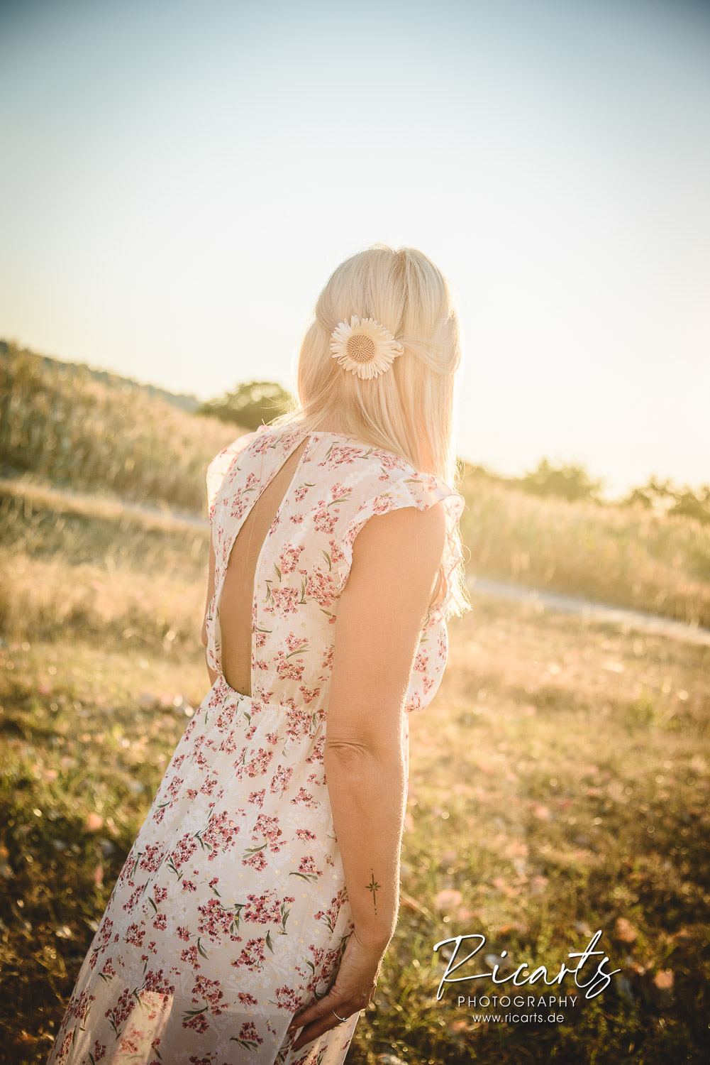 Junge-Frau-im-Sommerkleid-steht-auf-einer-Wiese