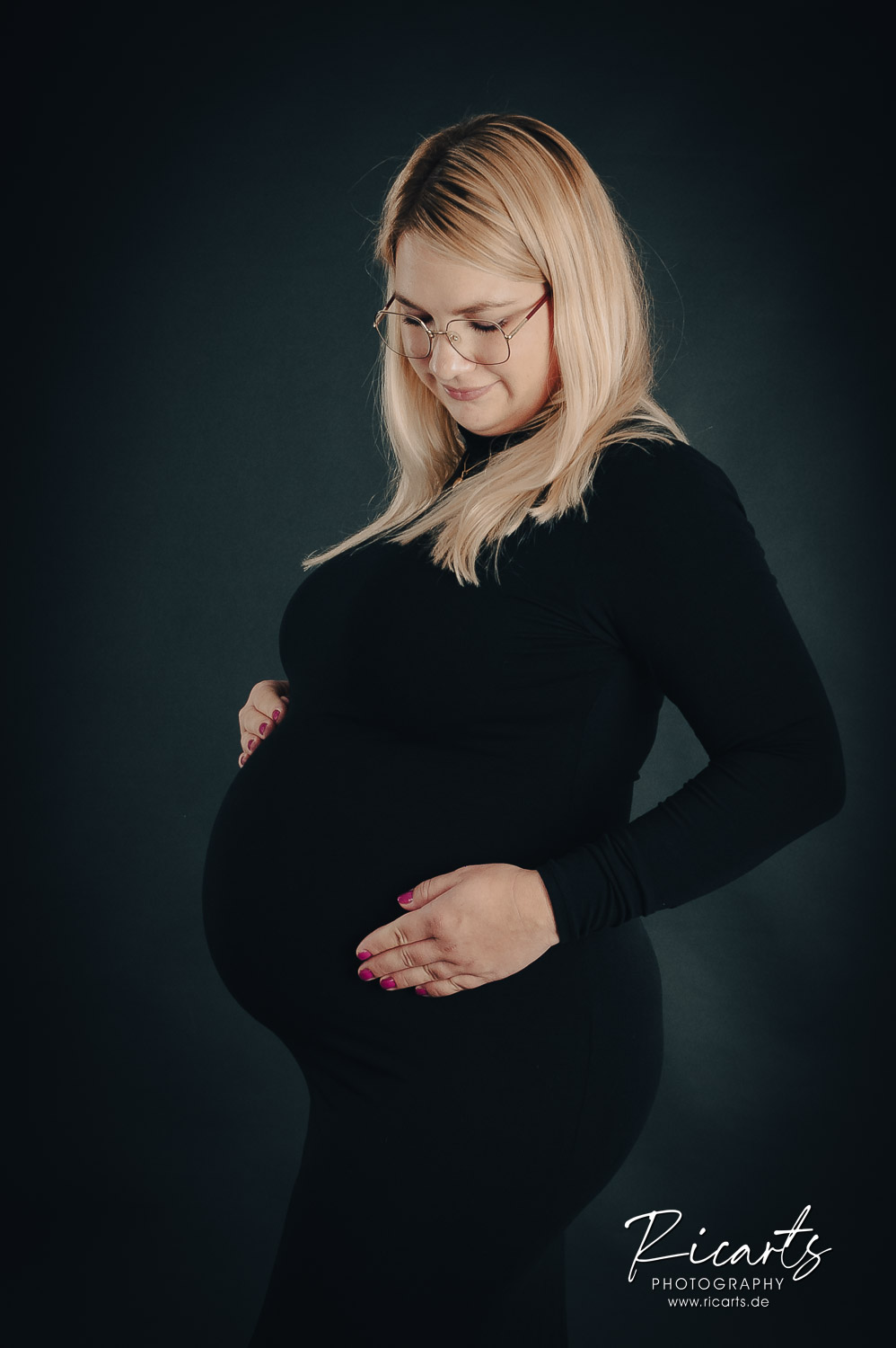 Junge-schwangere-Frau-haelt-Haende-an-ihren-Bauch