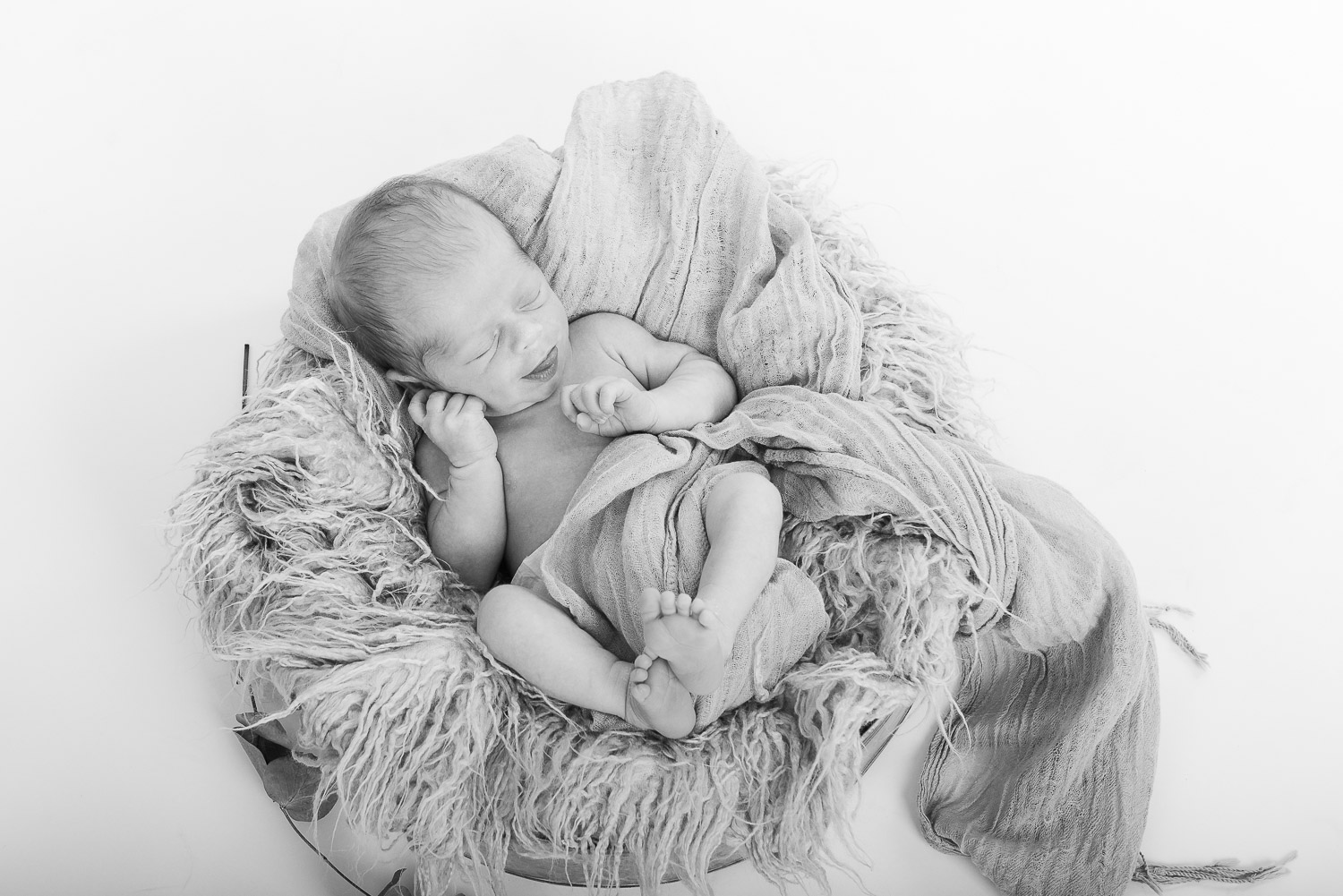 Neugeborenes-Baby-liegt-schlafend-auf-dem-Rücken-in-einer-Schale