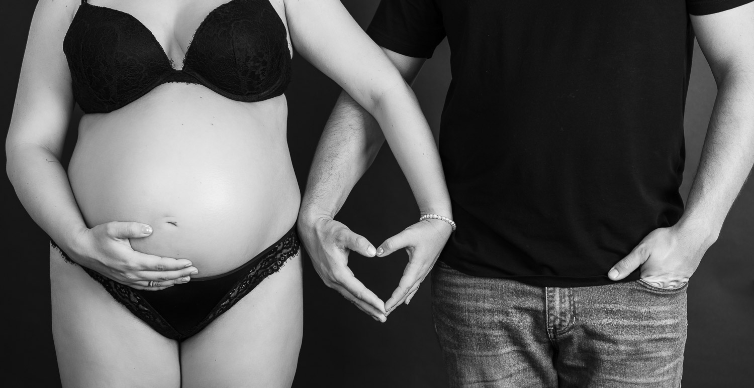 Junges-Paar-schwangere-Frau-halten-Hände-zu-einem-Herz