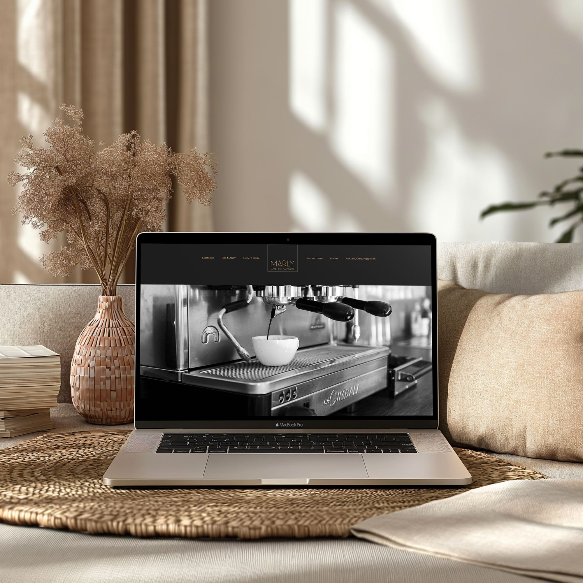 Webdesign-Laptop auf Couch zeigt Cafe-Website zur Präsentation
