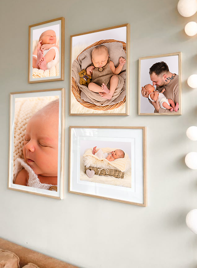 5 Newbornbilder in Holzrahmen hängen an einer Wohnzimmerwand über einer braunen Couch