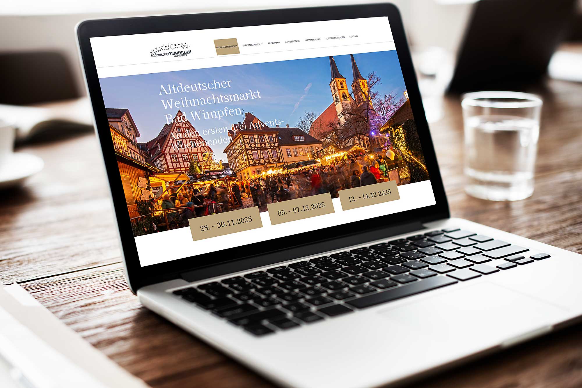 Website des Weihnachtsmarktes Bad Wimpfen wird auf einem Laptop angezeigt, der auf einem Holztisch liegt